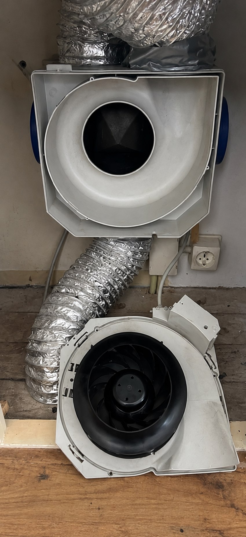Na reiniging: de zwarte ventilatorwaaier en grijze behuizing van de mechanische ventilatiebox
